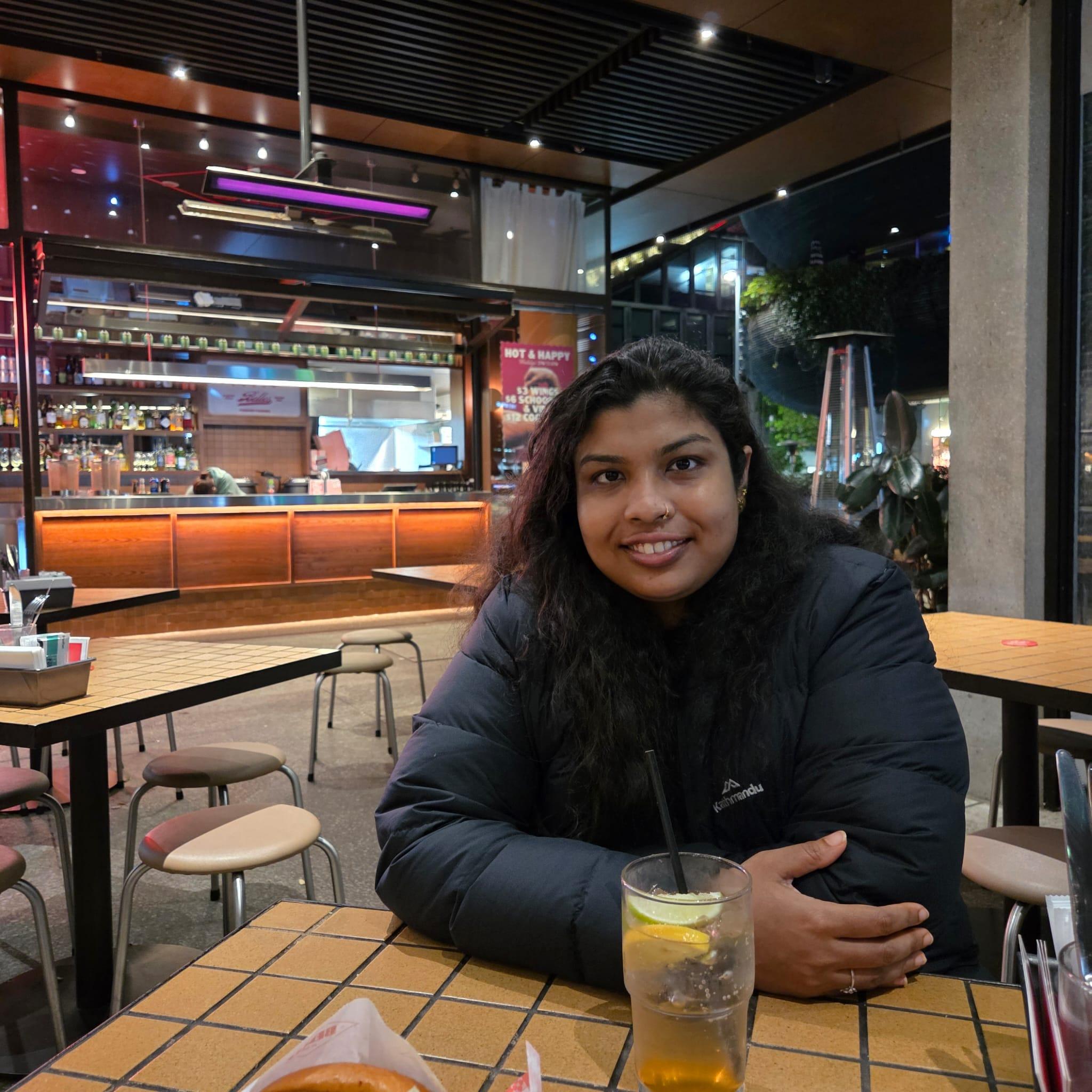 Fatma Ali smiling at an outdoor restaurant table at night